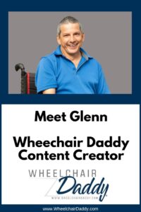 Man in a blue shirt who has cerebral palsy sitting in a wheelchair. Trees behind him.